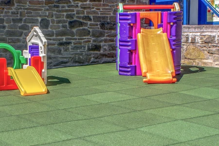 WARCO valbeschermingsmatten op een speelplaats voor kleine kinderen. Hier in mooi groen. WARCO maakt valbeveiligings tegels van 30mm tot 100mm dikkte. En hebben een maximale valbveiligings hoogte tot 3 meter!