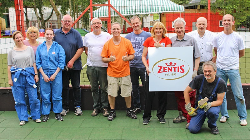 Nadat het werk klaar is, stelt een Zentis-team zich op voor een herinneringsfoto. De mannen en vrouwen staan op groene WARCO-vloeren.