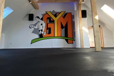 Een gym ruimte met een grote open ruimte, en een WARCO vloer ter beveiliging
