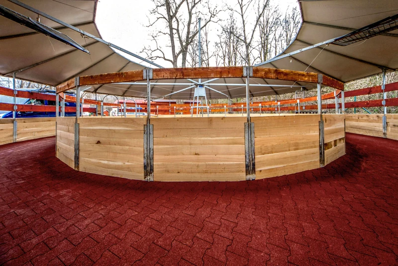 Zicht in een nieuw gebouwde stapmolen, overdekt met een zeildak en omheind met een band van lokaal hout. De hoefslag, d.w.z. het rijoppervlak, is gemaakt van rode dubbel-T composiet bestrating van WARCO.